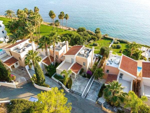 Zona residencial con varias casas, cada una con una terraza en la azotea y mobiliario exterior.