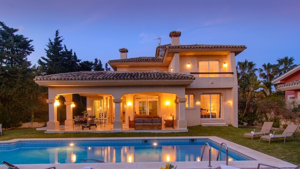 A two-story house with a swimming pool, outdoor seating, and a well-lit patio area. - 75m to Beach Luxury 4-Bed Villa with Heated Pool & Oasis Patio in Marbella (Marbella)