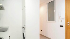 Un espace buanderie équipé d’un lave-linge et d’une petite fenêtre.