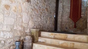 Un escalier en pierre avec un tissu rouge suspendu au mur.