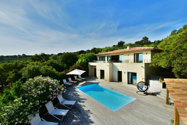 Une villa moderne dotée d’une piscine, d’un espace extérieur aménagé et d’une végétation luxuriante.