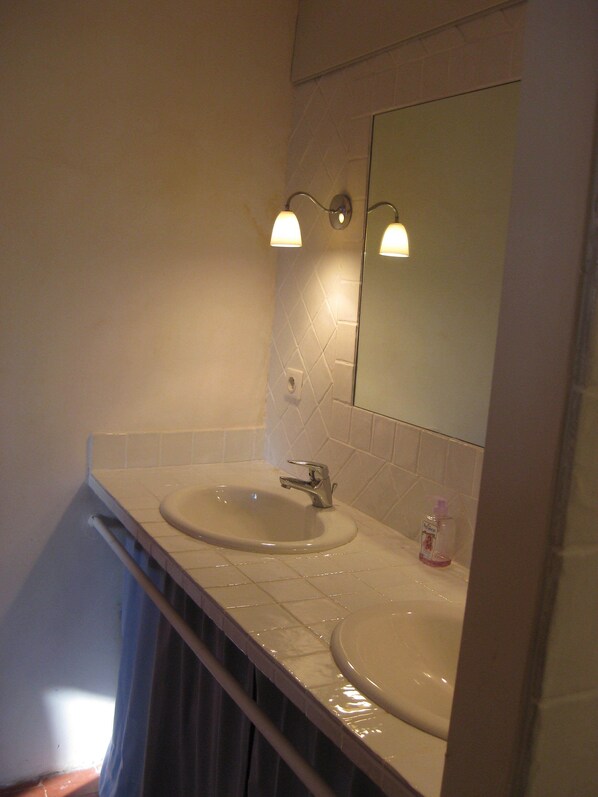 Un baño con dos lavamanos, un espejo y un perchero para toallas.