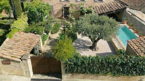 Una villa con piscina, rodeada de vegetación y vistas al campo.