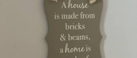 A decorative sign with a message about the importance of love and dreams in making a home.