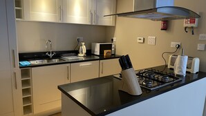 Una cocina moderna con una isla central, electrodomésticos de acero inoxidable y un microondas.