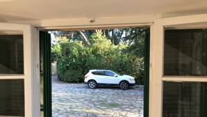 Un SUV bianco parcheggiato su un vialetto in pietra che conduce a una casa con stipite verde.