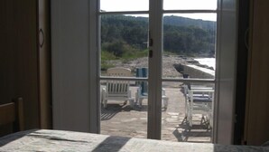 Una stanza con un letto, vista su un paesaggio roccioso e una porta che dà all'esterno.