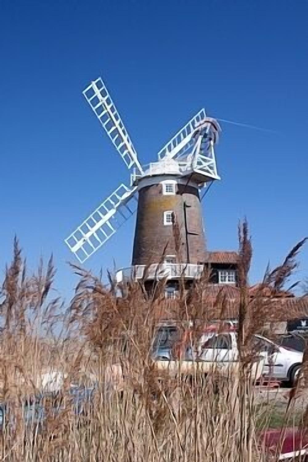 A windmill with a large, white, multi-bladed structure.
