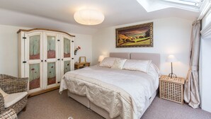 A bedroom with a bed, a wardrobe, a nightstand, a lamp, a picture on the wall, and a skylight. - Fern House, Grassington; central yet parking & quiet, light & period elegance (Grassington North Yorkshire)