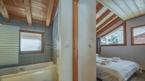 A bathroom with a bathtub, a window, and a towel rack.