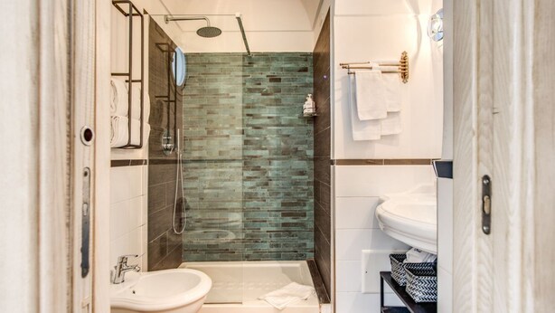 A modern bathroom with a glass shower enclosure, a white sink, and a bathtub.