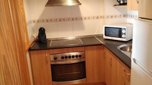 A compact kitchen with a stove, oven, microwave, and sink. - PENTHOUSE in Cabo de Gata with fabulous sea views (Carboneras (Almería))