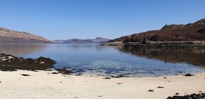 A calm lake with a sandy beach and rocky shoreline. - Large spacious cottage with fantastic views across the bay to Skye (no pet fee) (Glenelg)