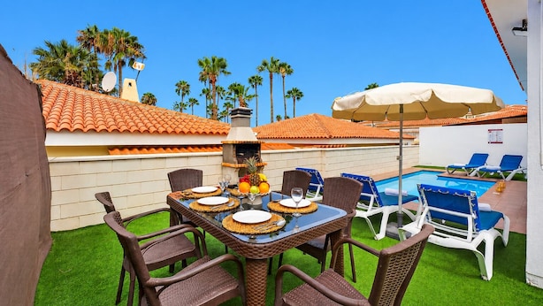 A patio with a table set for dining, surrounded by chairs, a pool, and lounge chairs. - BEAUTIFUL HOLIDAY HOME 273 WITH PRIVATE POOL (Callao Salvaje)