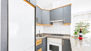 A modern kitchen with grey cabinetry, a white refrigerator, and a built-in oven. - BEAUTIFUL HOLIDAY HOME 273 WITH PRIVATE POOL (Callao Salvaje)
