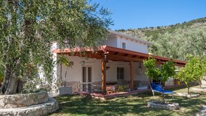 Un bâtiment blanc avec un toit rouge et une terrasse couverte.