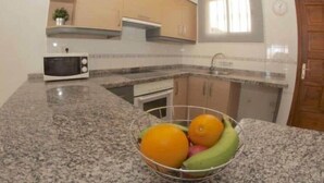 A kitchen with granite countertops, a microwave, a sink, and a window. - FABULOUS DUPLEX C6 WITH PRIVATE POOL (Adeje)
