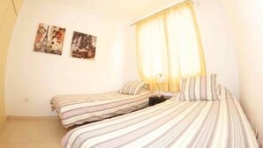 A small, well-lit room with two beds, a nightstand, and two wall-mounted pictures. - FABULOUS DUPLEX C6 WITH PRIVATE POOL (Adeje)