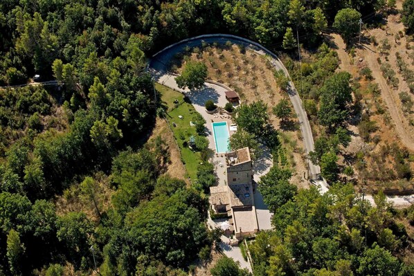 An aerial view of a property with a swimming pool, a small building, and surrounding wooded area. - Gorgeous loft with high ceilings, wooden interiors and panoramic terrace, pool (Spoleto)