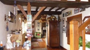A wooden interior with a staircase, a green sofa, and a wooden cabinet. - House / Villa - BERIGNY (Bérigny)