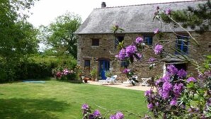 A stone house with a well-maintained lawn and purple flowers in the foreground. - House / Villa - BERIGNY (Bérigny)