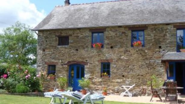 A stone building with a thatched roof, a blue door, and windows with flower boxes. There are lounge chairs and a table in the front yard. - House / Villa - BERIGNY (Bérigny)