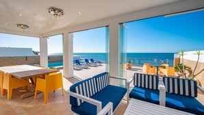 Un espace extérieur moderne, aménagé avec des sièges, une piscine et une vue sur l’océan.