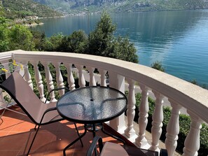 A balcony with a table and chairs overlooking a lake. - A unit, One bedroom, stunning views, waterfront, free secured parking (Lipci)