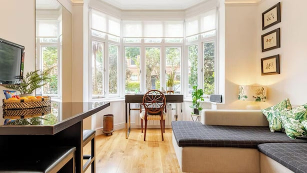 A bright room with a bay window, a dining table, a chair, and a sofa. - Beautiful One bedroom contemporary Interior Designed  Flat just off Kew Green (Kew Richmond)