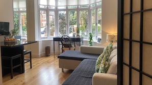 A modern living room with a bay window, a dining area, and a sofa. - Beautiful One bedroom contemporary Interior Designed  Flat just off Kew Green (Kew Richmond)