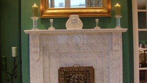 Une cheminée avec un manteau de cheminée, des bougies et un miroir encadré au-dessus.