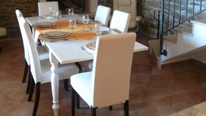 A dining area with a stone wall, a fireplace, white furniture, and a staircase. - Romantic-serene villa - heated swimming pool and superb view of the valley (Pengari)