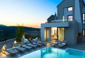 A modern house with a pool and lounge chairs. - Two Luxury Villas rented as one, ideal for big Groups - close to the beach!! (Chania)