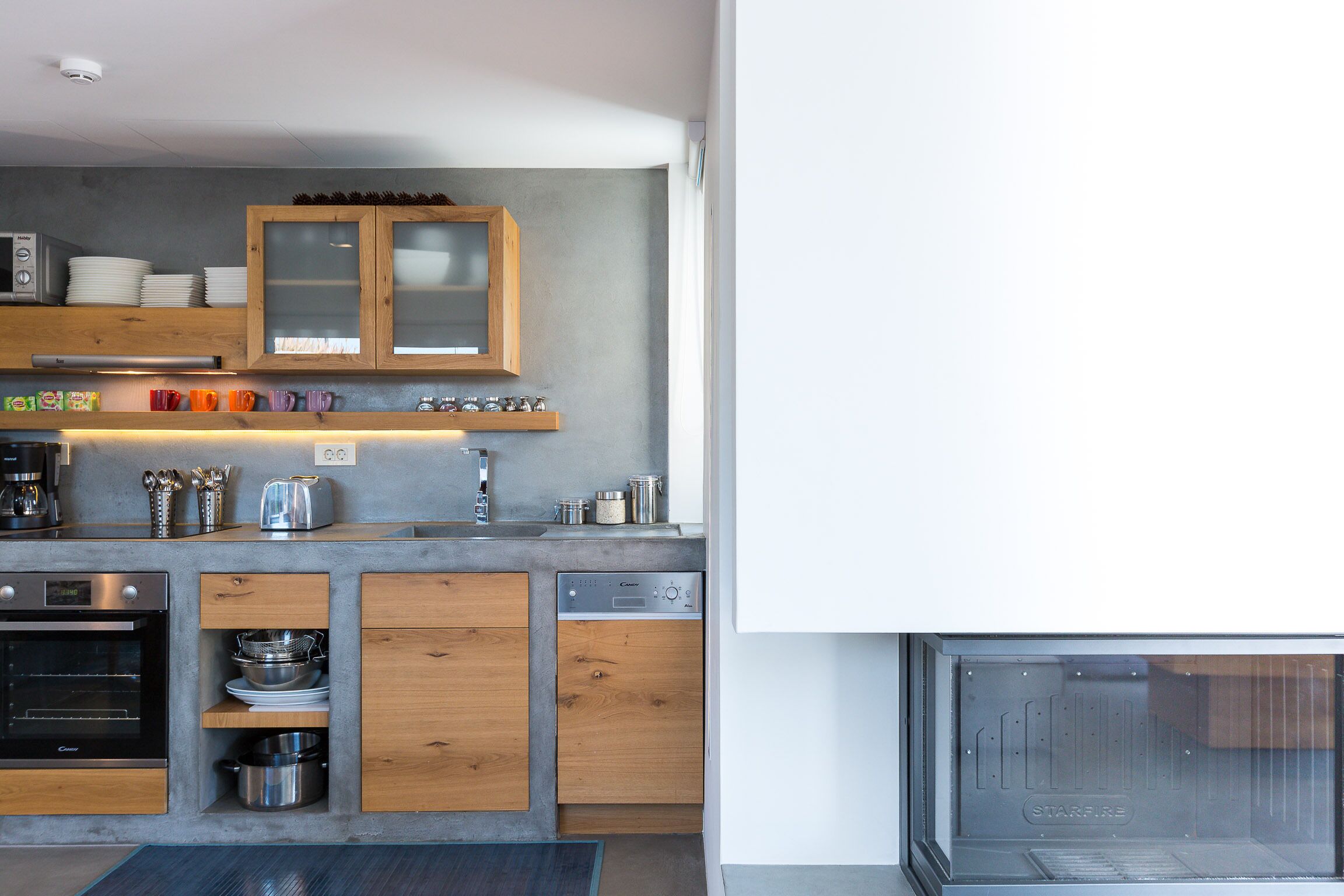 Eine moderne Küche mit Holzausstattung, einem eingebauten Backofen und einem Geschirrspüler.