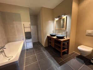 Bathtub, hair dryer, towels, toilet paper