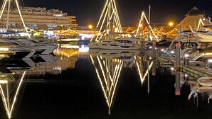 A marina at night with illuminated structures and boats.