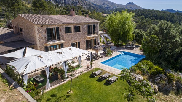 Une maison en pierre dotée d’une piscine, d’un espace extérieur aménagé et offrant une vue sur le paysage environnant.