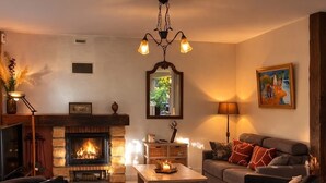 Ein Wohnzimmer mit Kamin, zwei Sofas, einem Couchtisch und einer Chandelier.