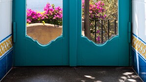 A turquoise door with a decorative arch and a hanging lantern.