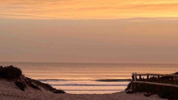 A beach with a wooden fence and dunes. - Salty Soul Beach House (Costa da Caparica)