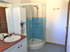 Een bad/douchecombinatie, een haardroger, handdoeken, zeep