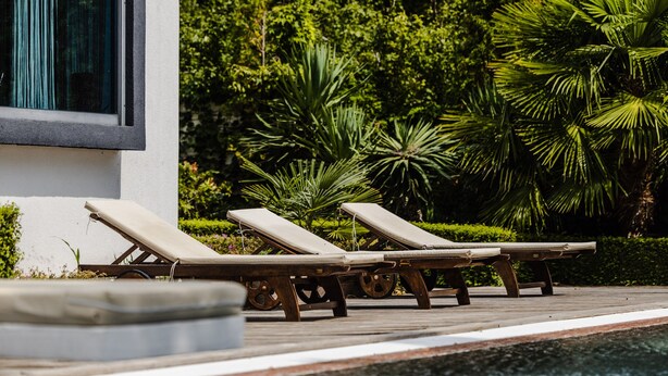 A poolside area with lounge chairs and a wooden deck. - Sunny Residence - Luxury private property with outstanding heated pool! (Kosharitsa)
