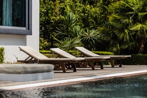 A poolside area with lounge chairs and a wooden deck. - Sunny Residence - Luxury private property with outstanding heated pool! (Kosharitsa)