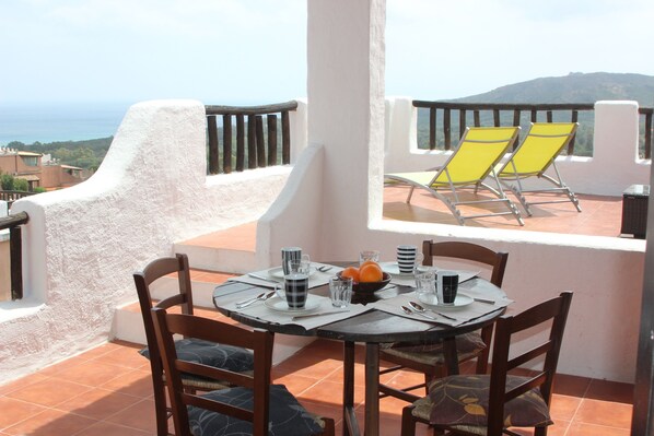 A dining table with chairs and a view of the sea. - Recently renovated cottage with breathtaking sea views (PULA)
