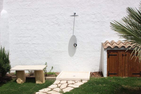 A stone pathway leading to a wooden door, a bench, and a wall-mounted light fixture. - Recently renovated cottage with breathtaking sea views (PULA)