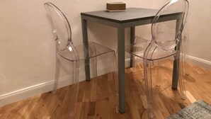 A small room with a square table and two clear plastic chairs. - Mimi Suite - Brand new flat Santa Maria Novella (Firenze)