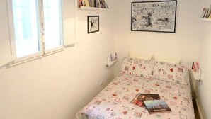 A bedroom with a bed, a window, and a ceiling with exposed beams. - Mimi Suite - Brand new flat Santa Maria Novella (Firenze)