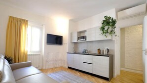 A modern apartment with a living room, kitchen, and a flat-screen TV. - Mimi Suite - Brand new flat Santa Maria Novella (Firenze)