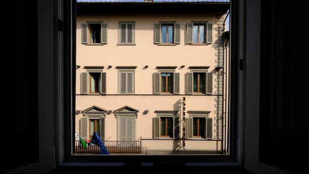 A view through a window of a building with multiple windows and balconies, featuring a traditional architectural style. - Mimi Suite - Brand new flat Santa Maria Novella (Firenze)