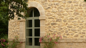 Un bâtiment en pierre avec une porte verte et des plantes en pot.